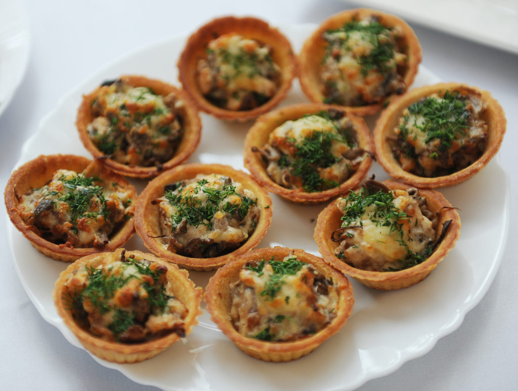 tartlets with chicken salad and herbs on white plate