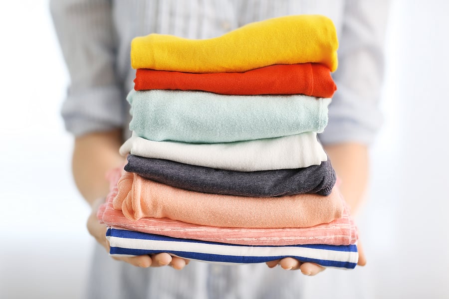 bigstock Woman holding stack of clothes 161462567 | Stay at Home Mum.com.au