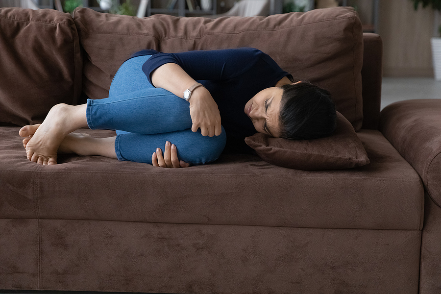 Woman in couch feeling phantom baby kicks